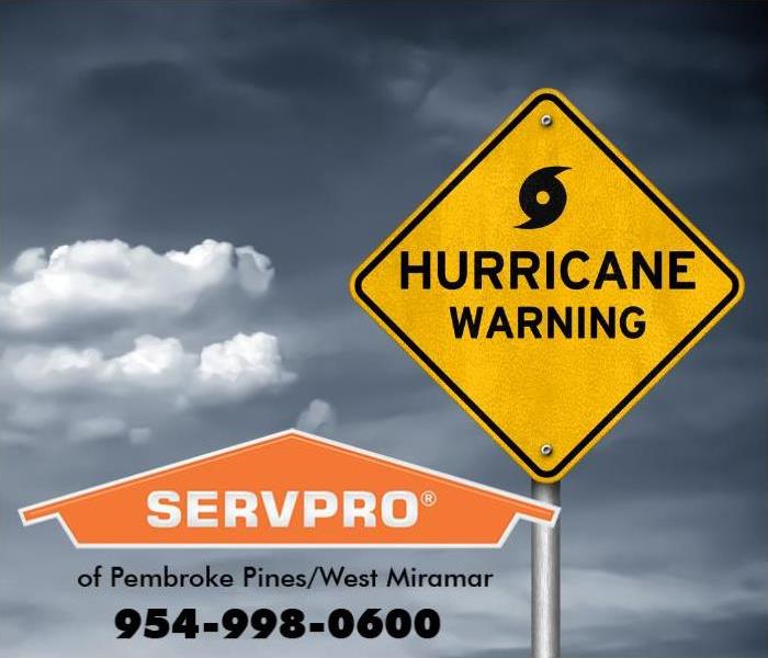 A hurricane warning sign is shown on a stormy day. 