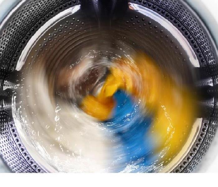 Looking down on washing machine spinning a load of clothes