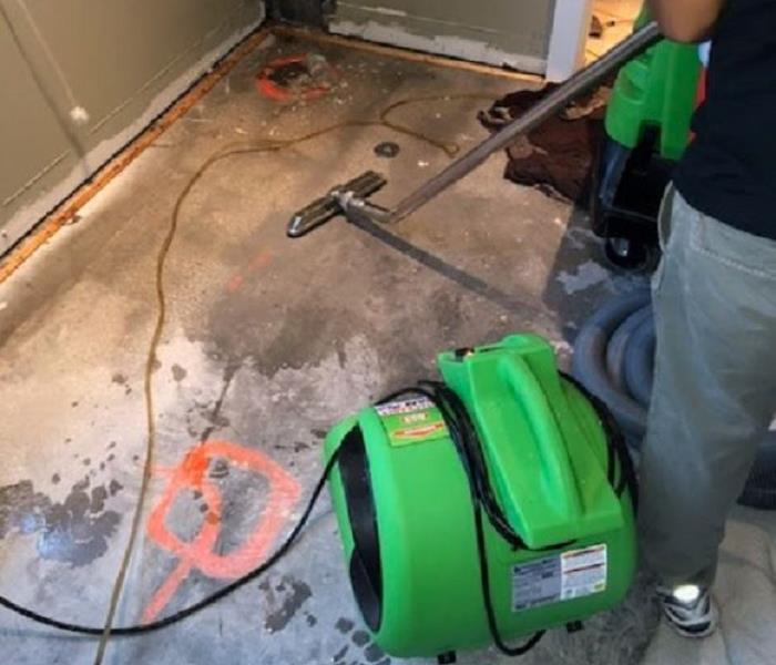 SERVPRO technician cleaning flood damaged room